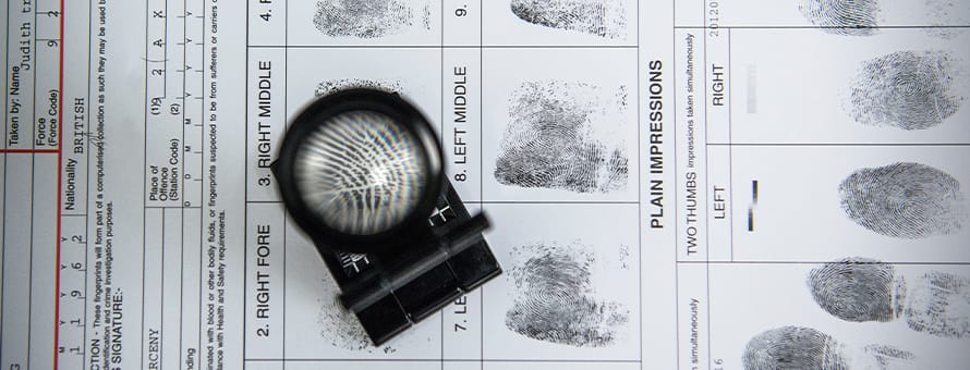 A fingerprint form with a magnifying glass.
