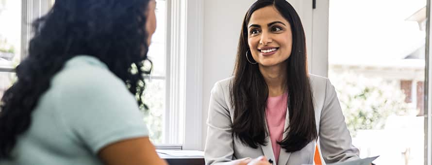 A woman speaking with another woman about her helping profession role
