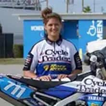 Marissa Markelon, who earned her bachelor's in business administration from SNHU in 2019, standing behind a racing motorcycle.