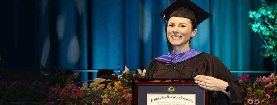 Military student holding diploma at graduation.