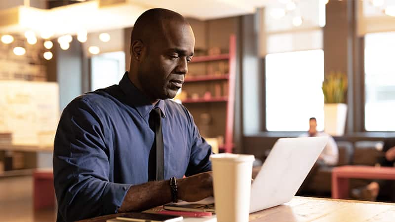 SNHU online degree program alum Jean Bisson, working from a laptop computer.