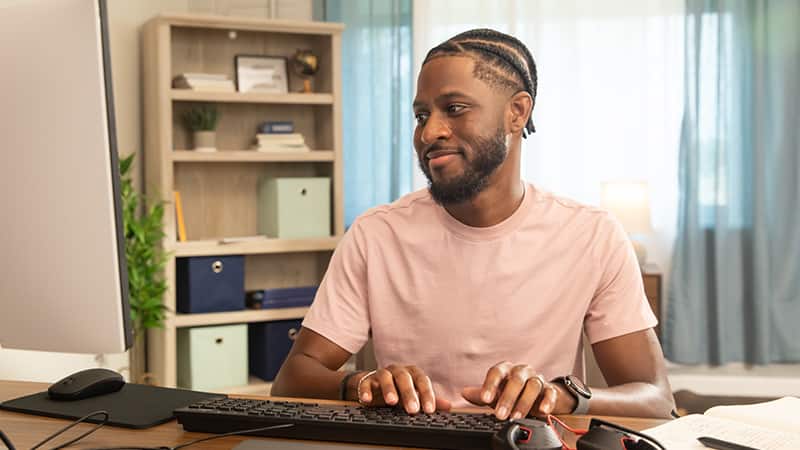 Matthew Seawright, who earned his online organizational leadership degree from SNHU in 2019, sitting at a desk typing on a computer.