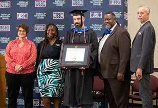 Nate Lohn receiving his diploma from officials