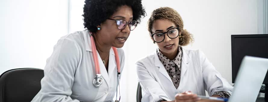Two nurse leaders on a video conferene with team members.