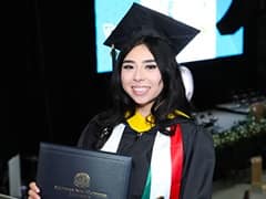 Paloma Rodriguez, who earned her bachelor's in computer science from SNHU in 2024, wearing her cap and gown and holding her diploma.