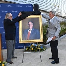 Artist Richard Whitney, left, unveiling a portrait of Mark A. Ouellette, right.