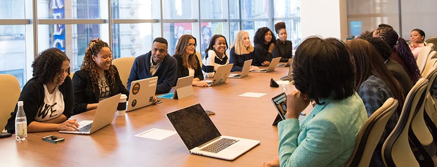 A group of public relations specialists discussing what they do while sitting at a conference table