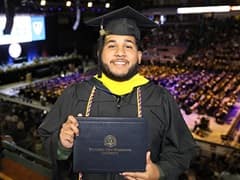 Remus Figueroa Orozco, holding his bachelor's in cybersecurity program diploma, at SNHU's 2024 commencement.