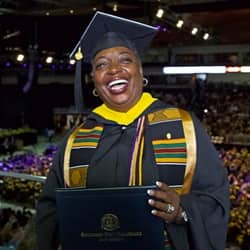 SNHU business administration graduate Robyn Roberts in her cap and gown and holding her diploma at the SNHU commencement ceremony.