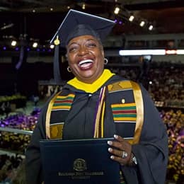 Robyn Roberts dressed in a graduation cap and gown, celebrating her bachelor’s degree in business administration from SNHU.