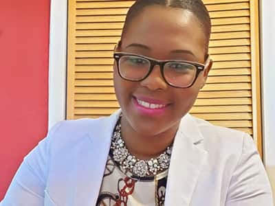 Dr. Sabrina Pink, who earned her online master's in public health degree from SNHU, in 2018, wearing glasses and a white jacket.