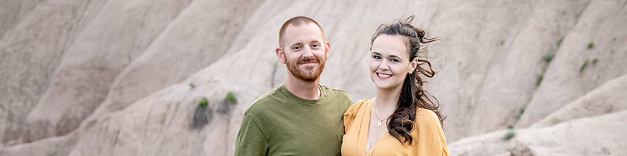 SNHU student and South Dakota resident Tara Yonce wearing a yellow dress and standing next to a man and young boy.