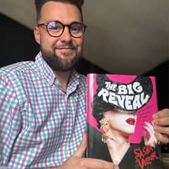 Spencer Hensel, copy director at SNHU, holding a book