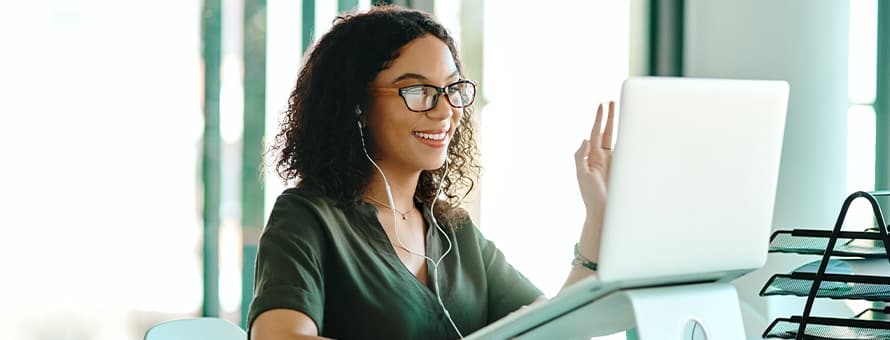 A woman on her laptop staying engaged with her colleagues while working from home. 