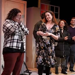 SNHU graduate Stephanie Gould with her cast members on stage