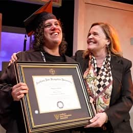 SNHU graduate Stephanie Gould holding her diploma with SNHU's executive vice president and university provost, Lisa Marsh Ryerson