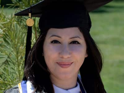 Susana Ellis, who earned her online bachelor's in photography from SNHU in 2020, wearing her graduation cap and gown. 