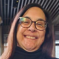 Tami Brouillette, adjunct marketing faculty at SNHU wearing glasses and a black turtleneck.