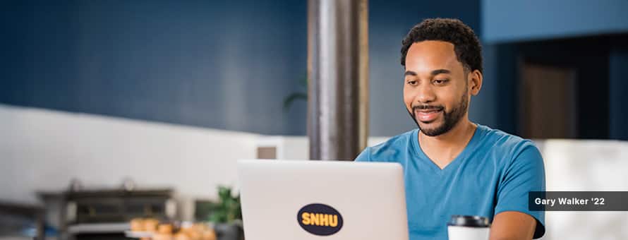 Gary Walker '22, who earned his MBA degree online in Engineering Management, working from a laptop in an office setting.
