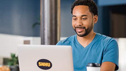 Gary Walker '22, who earned his MBA degree online in Engineering Management, working from a laptop in an office setting.