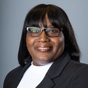 Dr. Tharinia Oyegun, associate dean of online criminal justice and human services program at SNHU, wearing a black blazer and white shirt.