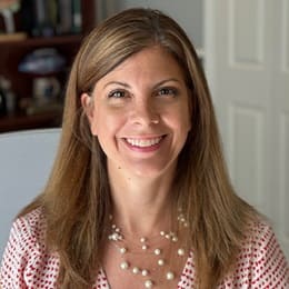 SNHU psychology instructor Tiffany Daniels wearing a red and white polkadot blouse and a multi-strand white pearl necklace.