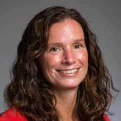 Tracy Micali, associate director of career development at SNHU in a red shirt against a grey background.