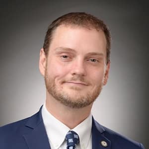 Dr. Trebor Evans, an adjunct instructor in SNHU's online master's in IT program, wearing a blue suit and tie.
