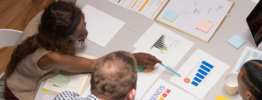 A marketing team sitting together at a table going over charts and marketing trends