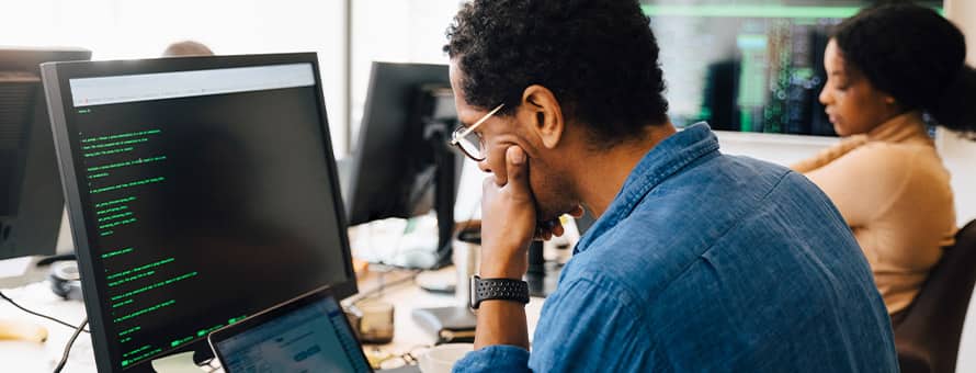 A professional in a cyber security role working on a computer.