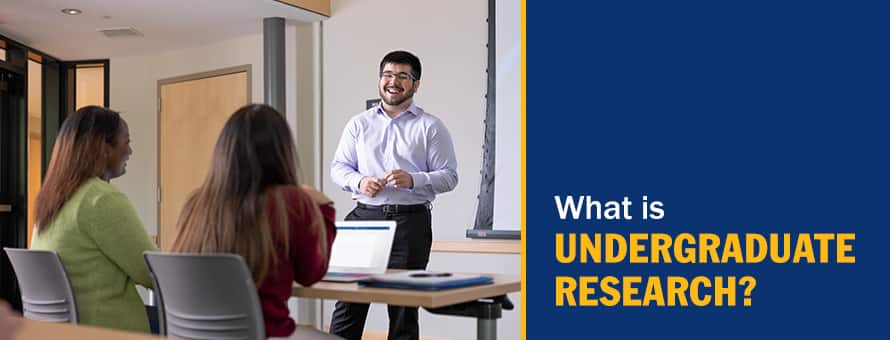 An undergraduate student presenting his research in a classroom and the text What is Undergraduate Research.