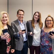 A group of three undergraduate students and their professor who worked together on research.