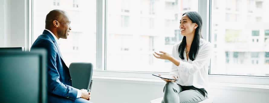 A man and a woman sitting across from one another in a business meeting