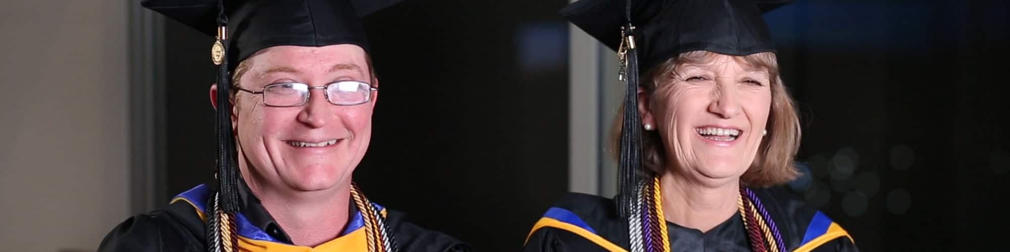 Dennis Perdue and his mother, Robin Perdue, West Virginia residents and SNHU graduates, wearing their caps and gowns.