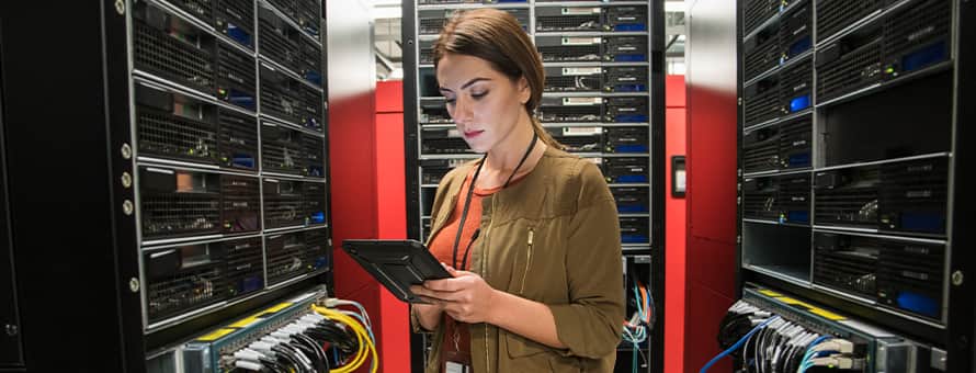 A woman with an associate degree in IT working in a server room.