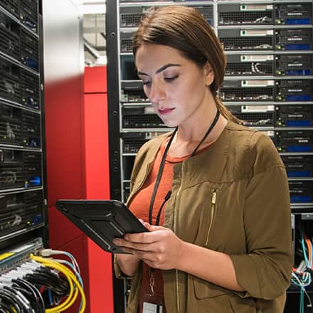 A woman with an associate degree in IT working in a server room.