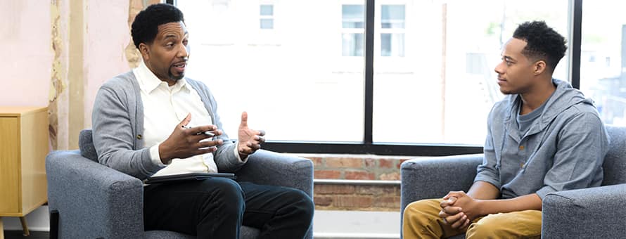 A counselor doing his job, speaking with a client he’s sitting across from.