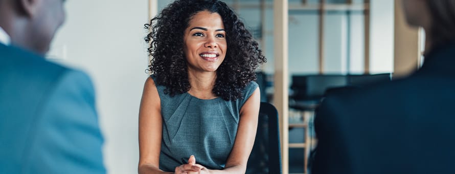 A woman sitting in on a meeting with two other people discussing what an MS degree is