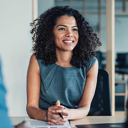 A woman sitting in on a meeting with two other people discussing what an MS degree is