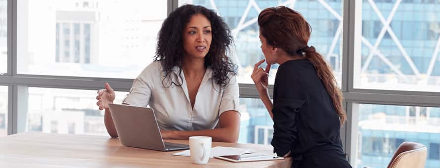 Two HR professional's in discussion at a meeting