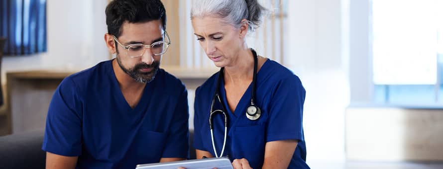 Two healthcare professionals in a Magnet hospital, reviewing a patient chart