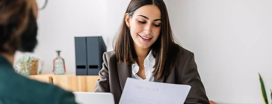 A woman sitting at a table going over her resume with an advisor