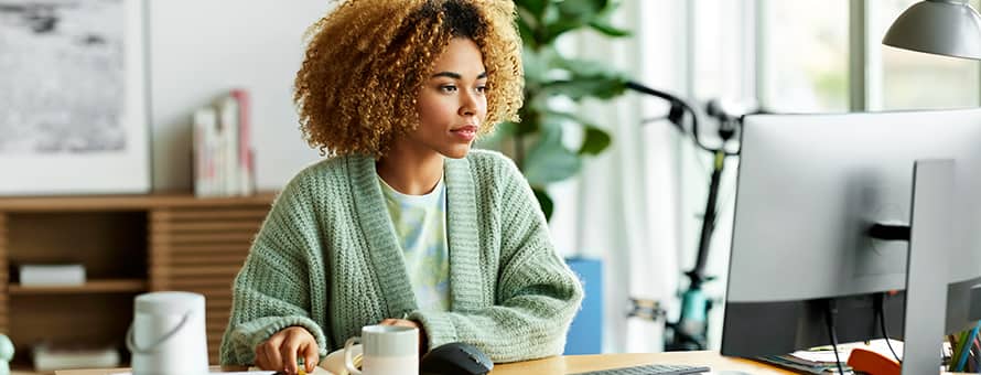 A professional upskilling at her desk, using a computer.