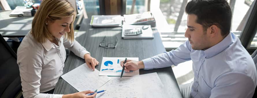 A sales manager sitting with a client going over paperwork
