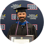 Nathaniel Lohn, a Maryland resident and SNHU graduate, wearing his cap and gown and holding his framed diploma.